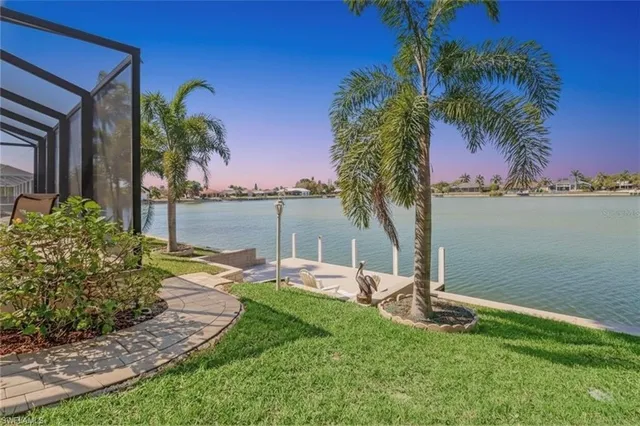 a view of a backyard with a table and chair under an umbrella
