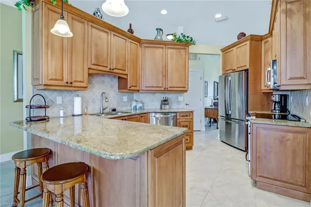 a kitchen with stainless steel appliances granite countertop a sink refrigerator and cabinets