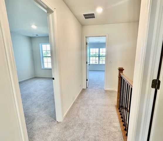 an entryway with wooden floor and a bathroom