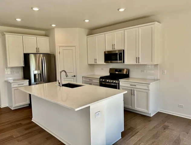 a kitchen with stainless steel appliances a refrigerator sink and white cabinets
