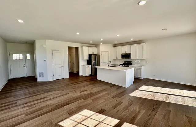 a view of kitchen with granite countertop cabinets and refrigerator