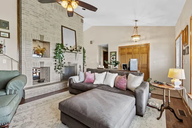 a kitchen with stainless steel appliances granite countertop a stove top oven a refrigerator a sink and chairs