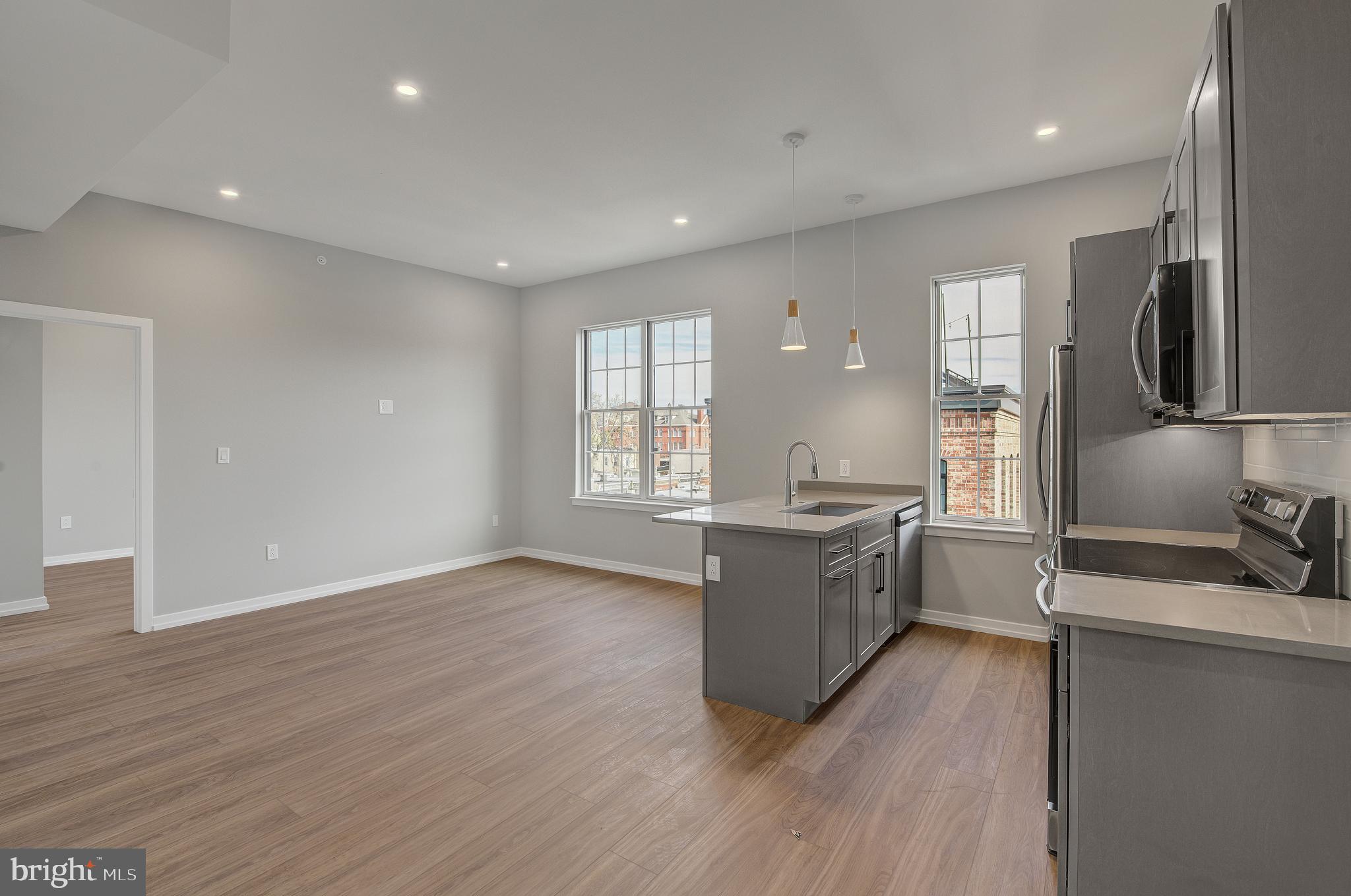 2445 Innovator Way, Unit 4I Philadelphia, PA 19146 - Photo 1 of 12 a large kitchen with stainless steel appliances granite countertop a large stove a sink dishwasher a refrigerator and white cabinets with wooden floor