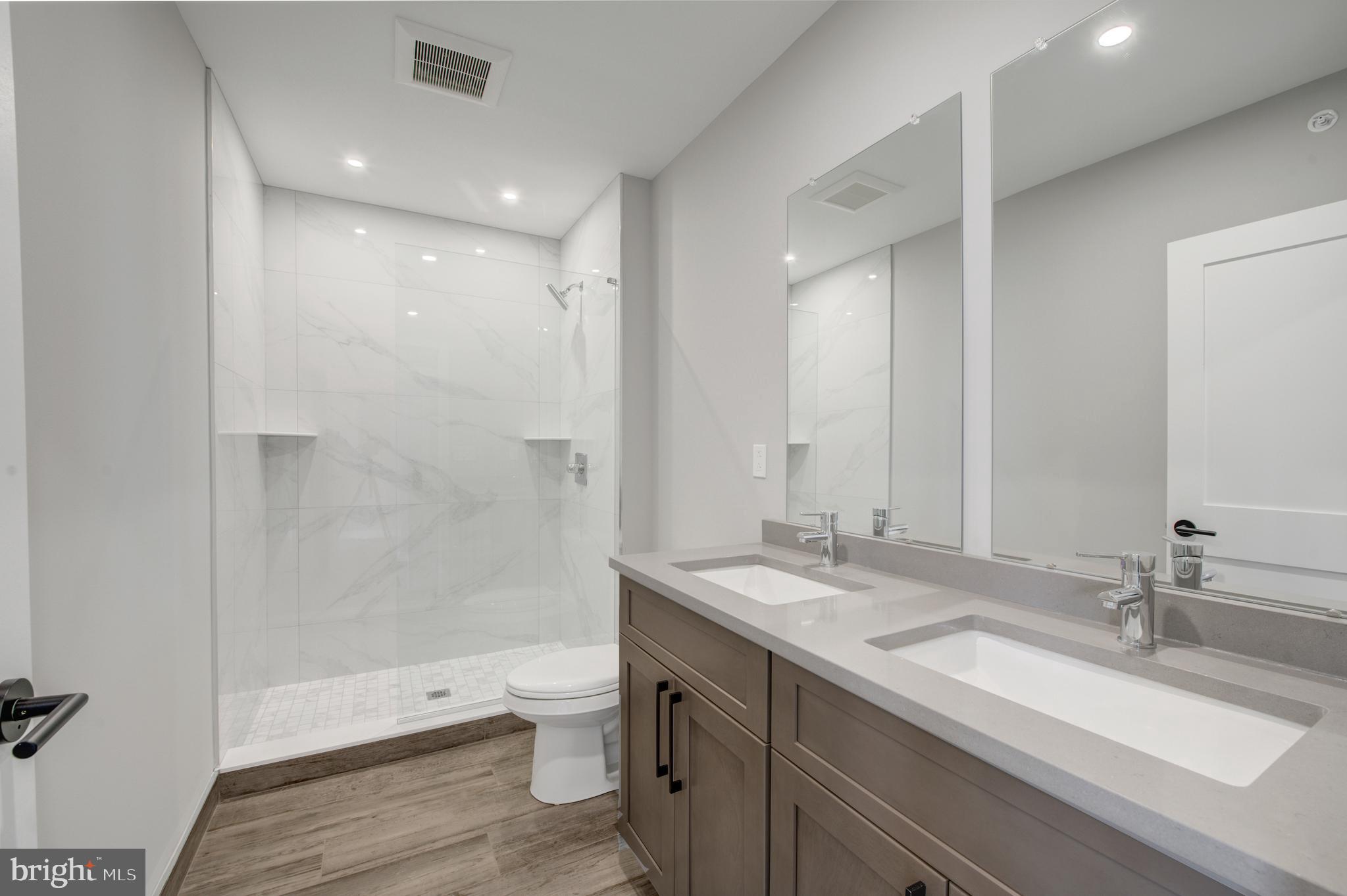 2445 Innovator Way, Unit 4I Philadelphia, PA 19146 - Photo 11 of 12 a bathroom with a double vanity sink toilet and shower