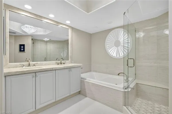 a bathroom with a sink a toilet a mirror and shower