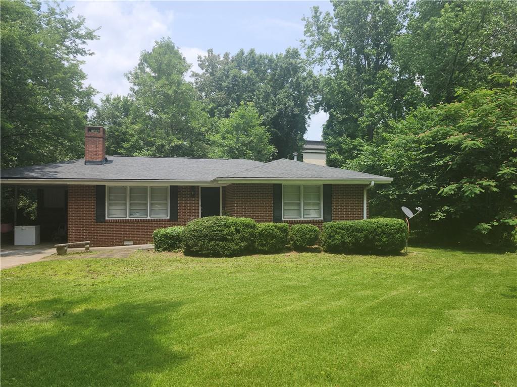 a view of a house with a yard and large tree