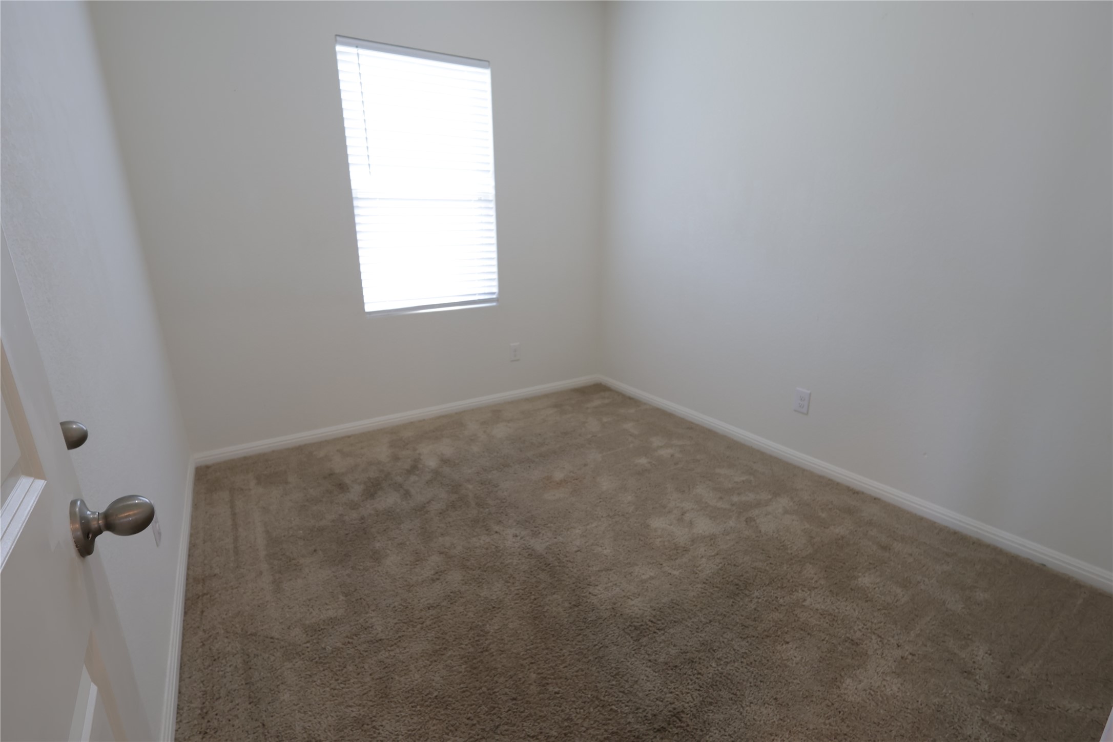 250 Seneca Loop Kyle, TX 78640 - Photo 8 of 22 A well-lit, quiet bedroom with plush carpeting, offering a cozy private retreat.