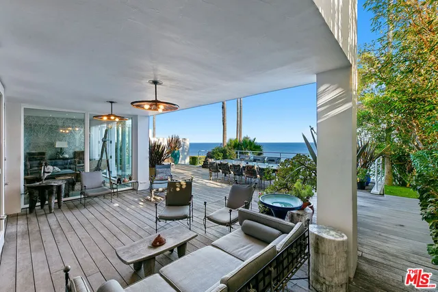 a bedroom with a bed and large windows