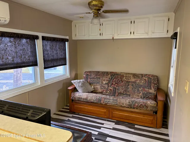 a living room with furniture and a painting on the wall