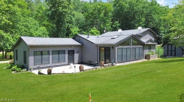 86532 North Bay Road Scio, OH 43988 - Photo 3 of 48 Expansive green lawn with a gray siding exterior featuring a multi-level roofline, a patio space, a large sunroom with floor-to-ceiling windows, and a separate storage shed