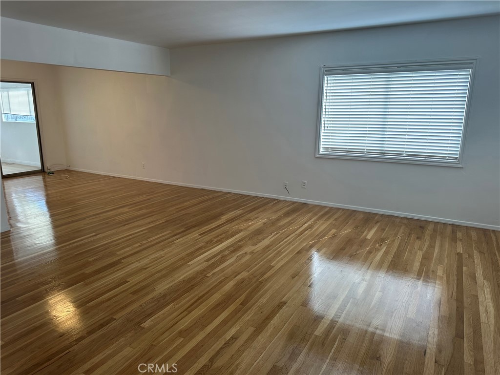 803 1/2 East Newmark Avenue Monterey Park, CA 91755 - Photo 3 of 9 a view of an empty room with wooden floor and a window