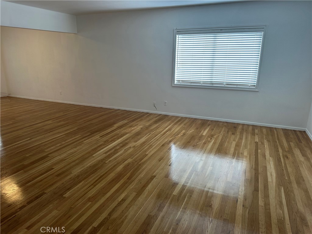 803 1/2 East Newmark Avenue Monterey Park, CA 91755 - Photo 4 of 9 an empty room with wooden floor and windows