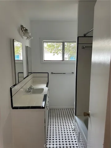 a bathroom with a granite countertop sink a toilet a mirror and window