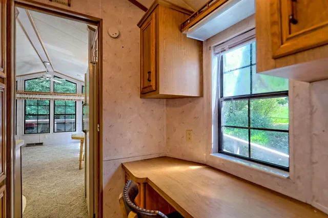 a living room with furniture a flat screen tv and a large window