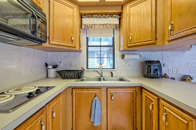 a kitchen with kitchen island granite countertop a sink cabinets and stainless steel appliances