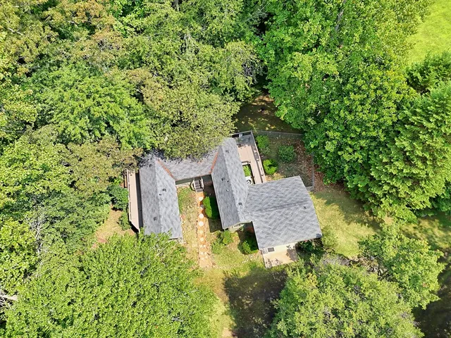 an aerial view of a house with a yard balcony and furniture