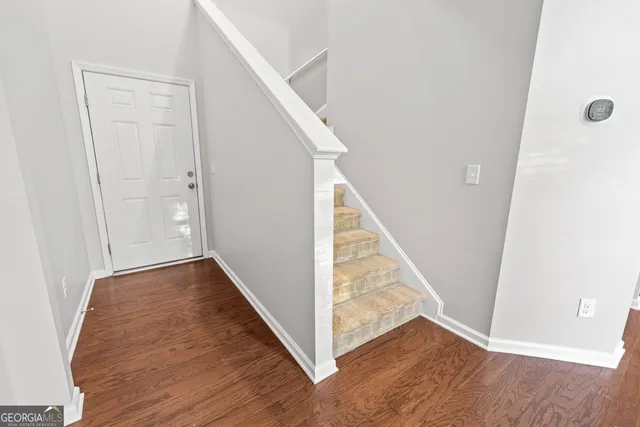 a view of a hallway with wooden floor and staircase
