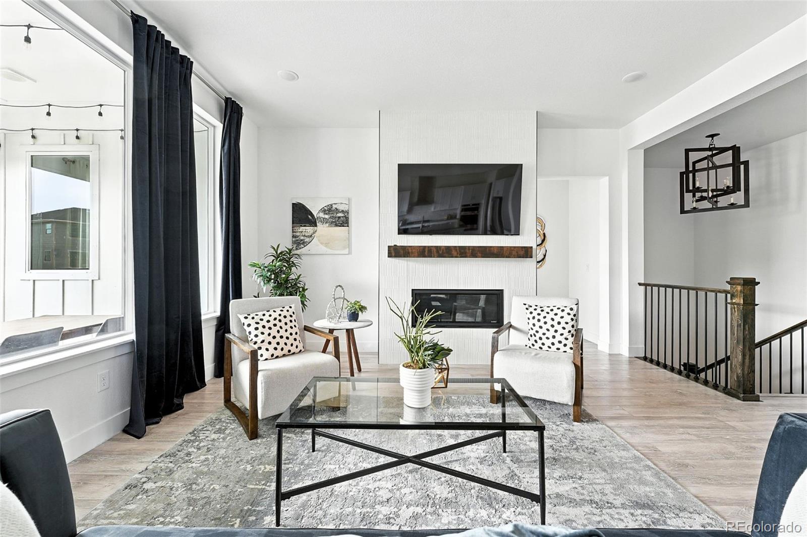 4855 Saddle Iron Road Castle Rock, CO 80104 - Photo 19 of 50 a living room with furniture a flat screen tv and a fireplace