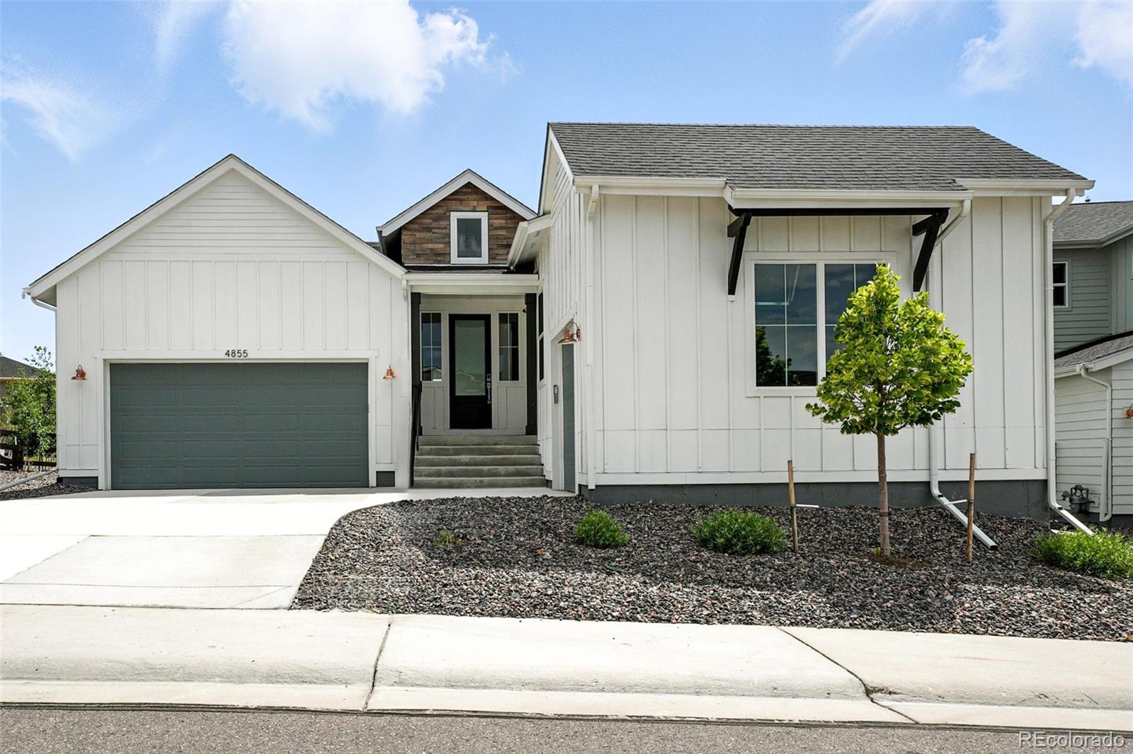 4855 Saddle Iron Road Castle Rock, CO 80104 - Photo 3 of 50 a front view of a house with a yard and garage