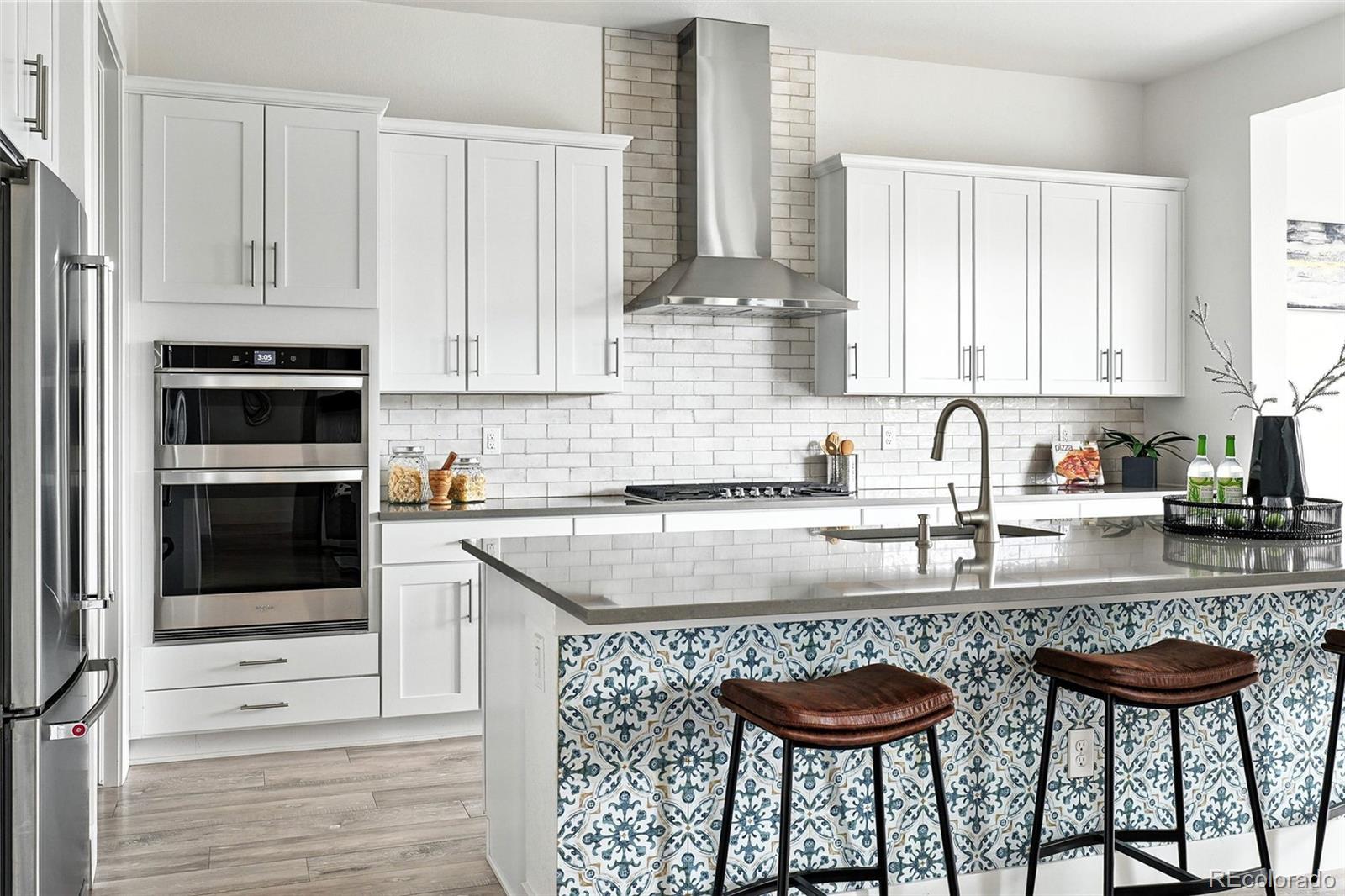 4855 Saddle Iron Road Castle Rock, CO 80104 - Photo 6 of 50 a kitchen with stainless steel appliances granite countertop a stove a sink and white cabinets