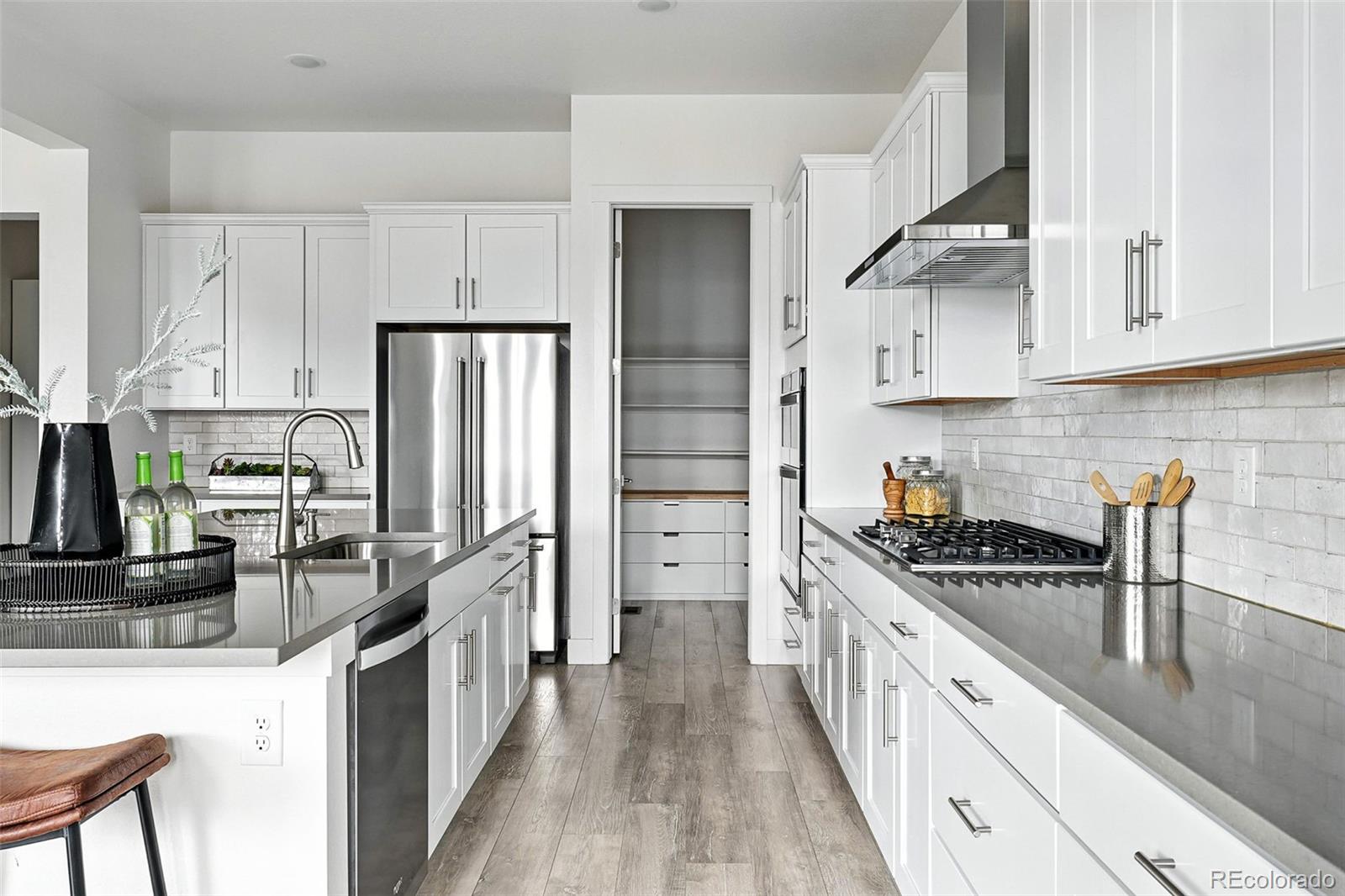 4855 Saddle Iron Road Castle Rock, CO 80104 - Photo 9 of 50 a kitchen with kitchen island a counter space a sink a stove and refrigerator