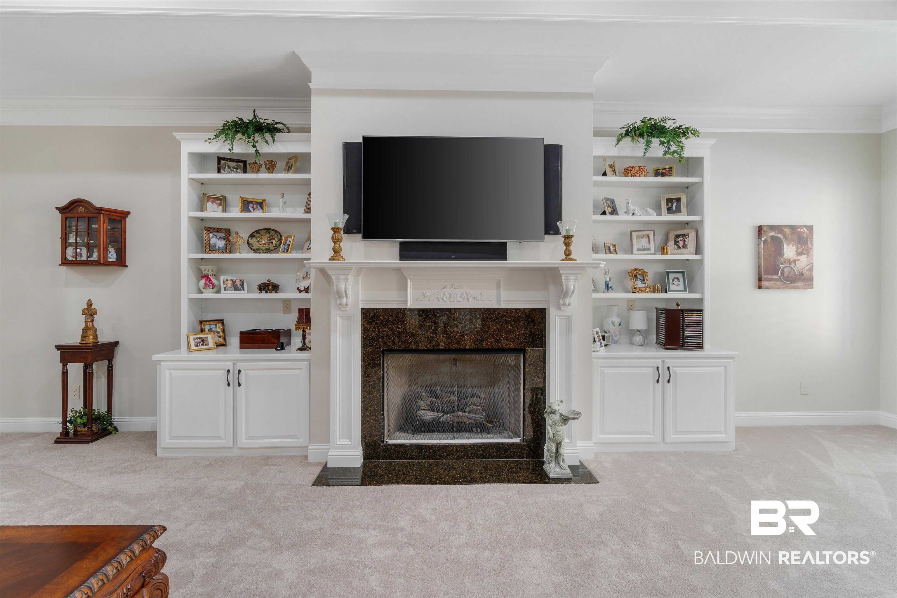 11281 Redfern Road Daphne, AL 36526 - Photo 11 of 80 Unfurnished living room featuring a high end fireplace, crown molding, built in features, and light colored carpet