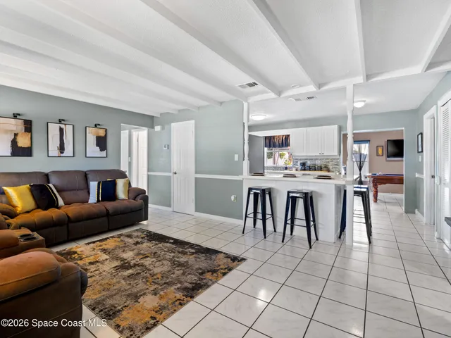 a living room with furniture a dining table and kitchen view
