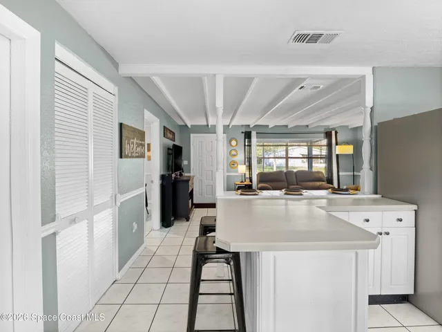 a large kitchen with kitchen island a large counter top space and stainless steel appliances