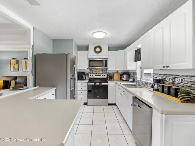 a kitchen with stainless steel appliances a refrigerator sink and cabinets