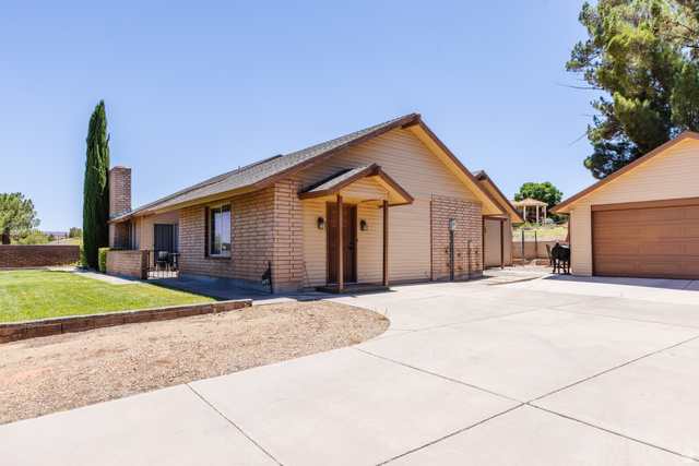 1470 Redwood Tree Street St. George, UT 84790 - Photo 34 of 53 Brick and siding exterior featuring a covered entry, attached garage with a brown door, and a concrete driveway