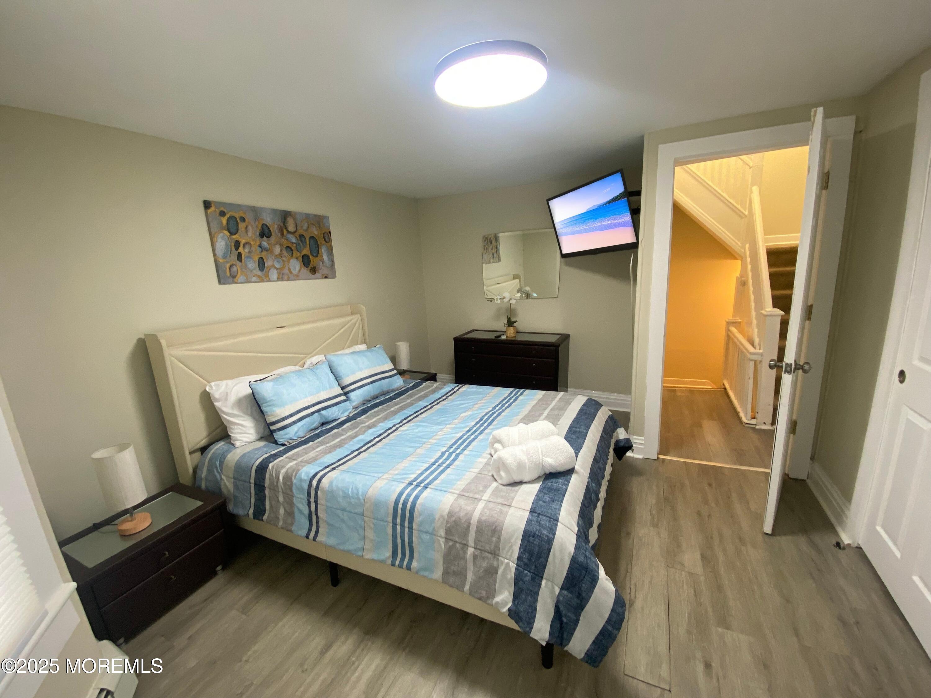 1204 Emory Street, Unit 2 Asbury Park, NJ 07712 - Photo 14 of 33 a bedroom with a bed and a painting on the wall