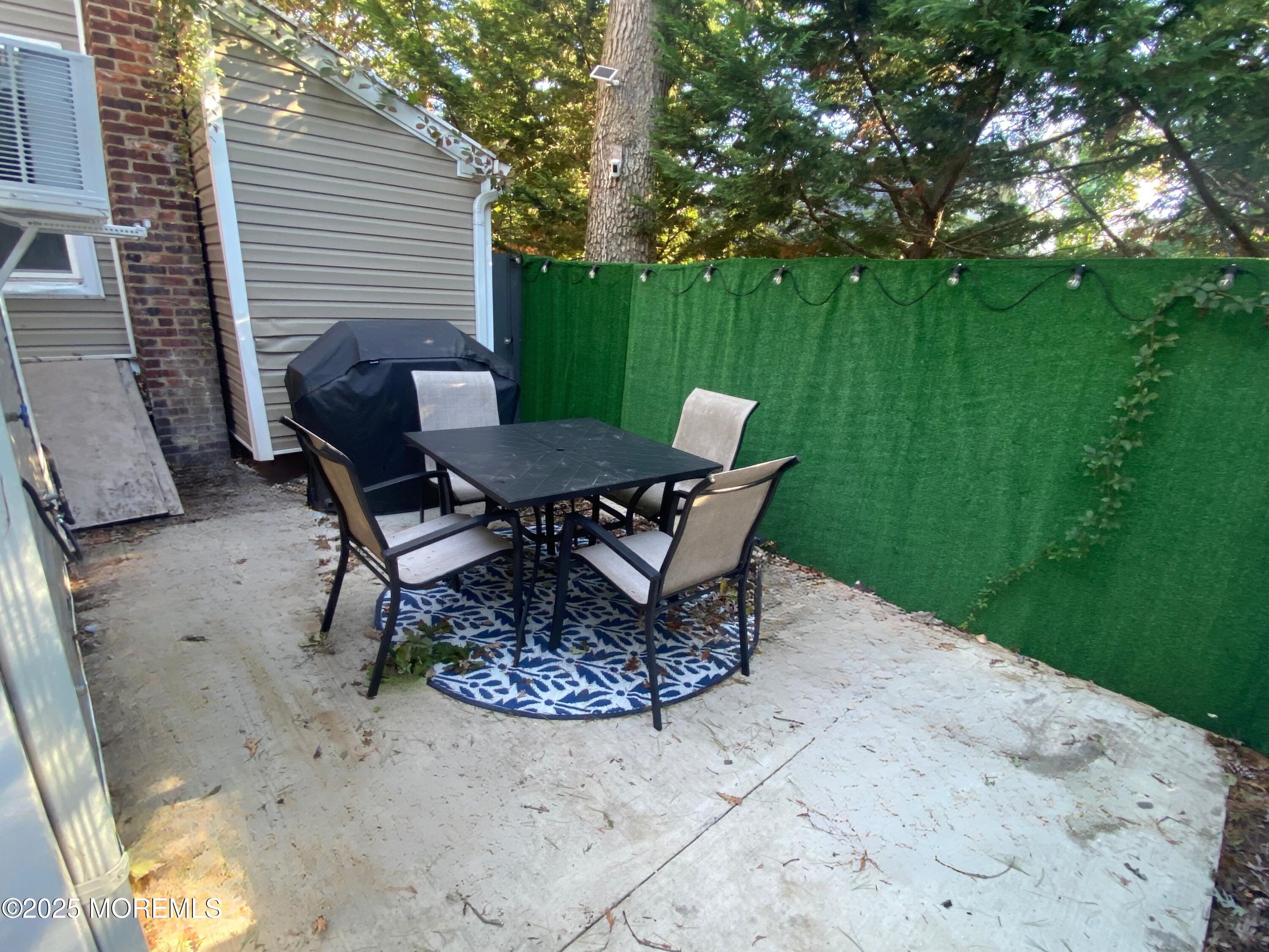 1204 Emory Street, Unit 2 Asbury Park, NJ 07712 - Photo 19 of 33 a view of a backyard with table and chairs and potted plants