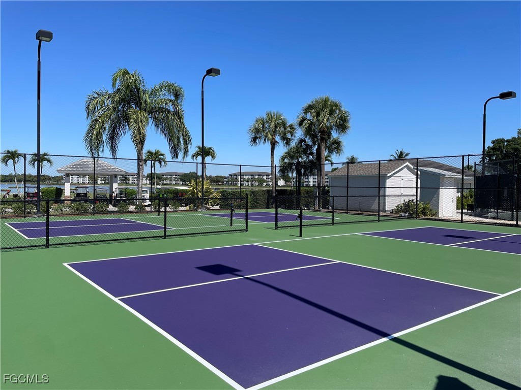 10461 Washingtonia Palm Way, Unit 3435 Fort Myers, FL 33966 - Photo 27 of 36 a view of tennis court with palm trees