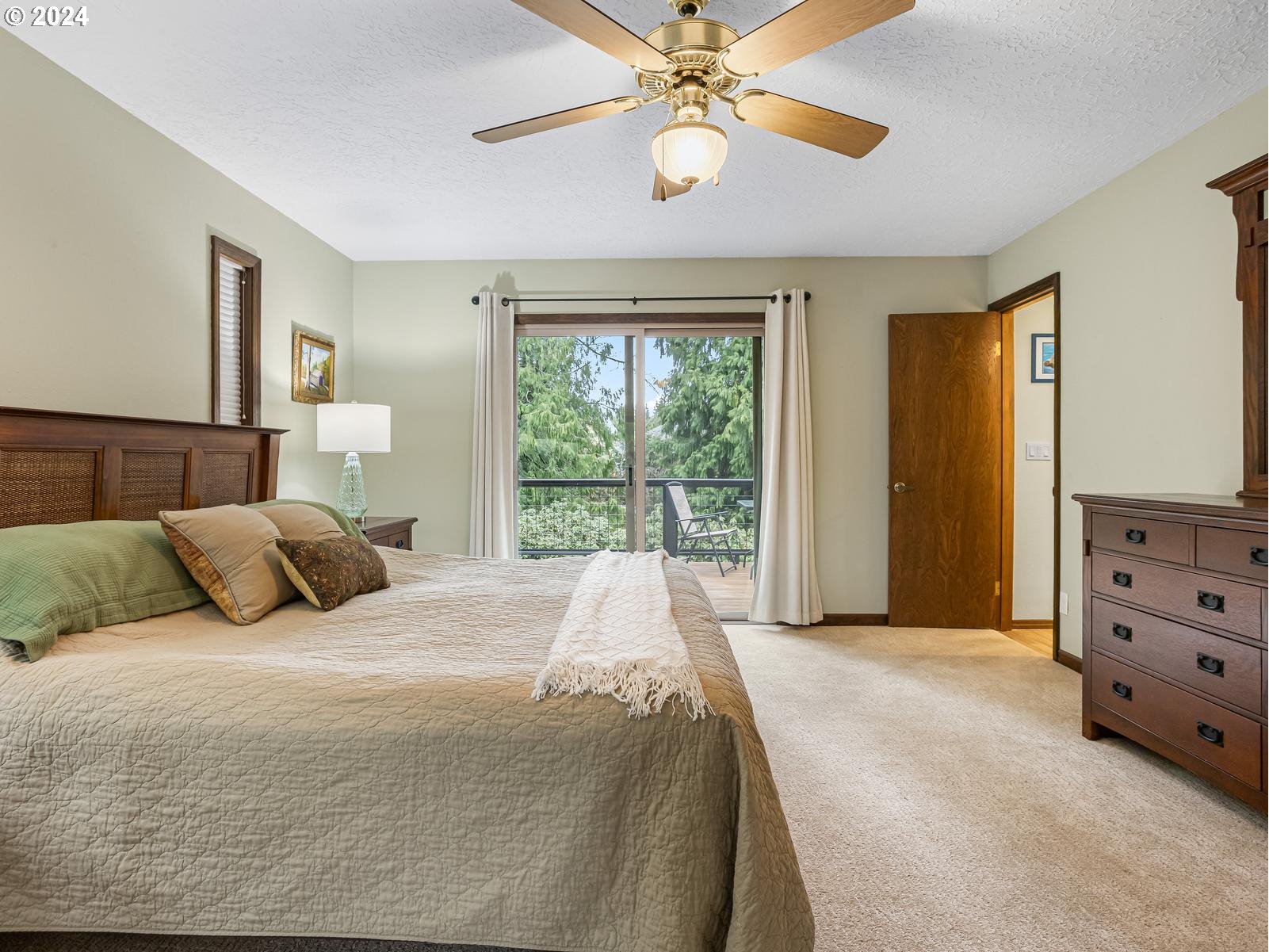 18550 Southeast Jacoby Road Sandy, OR 97055 - Photo 19 of 47 a bedroom with a large bed and a chandelier