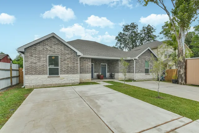 front view of a house with a yard and potted plants