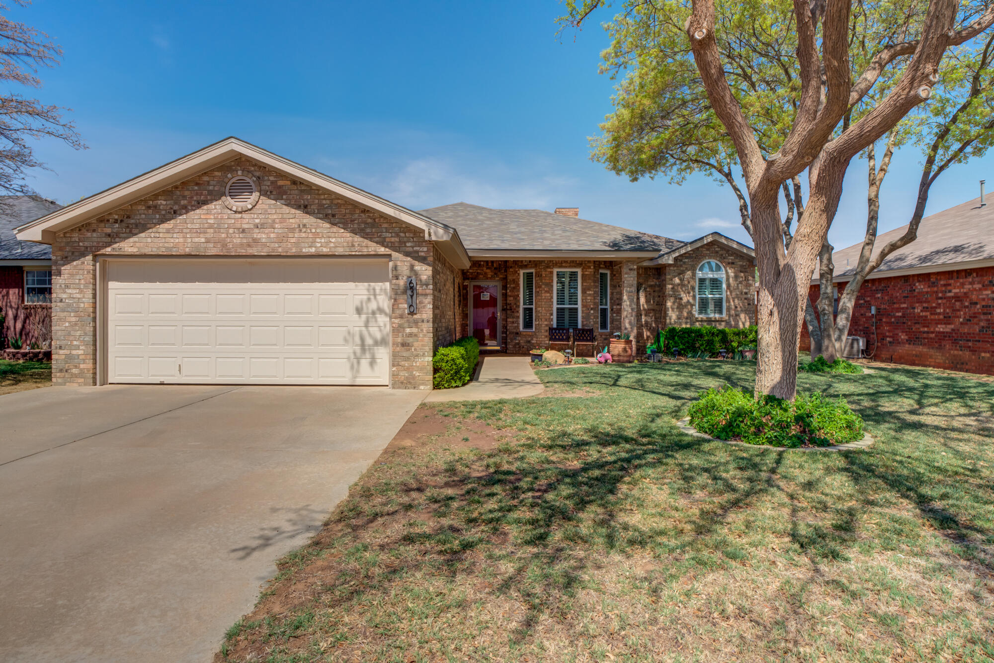 6310 8th Street Lubbock, TX 79416 - Photo 1 of 45 a front view of a house with a yard and garage