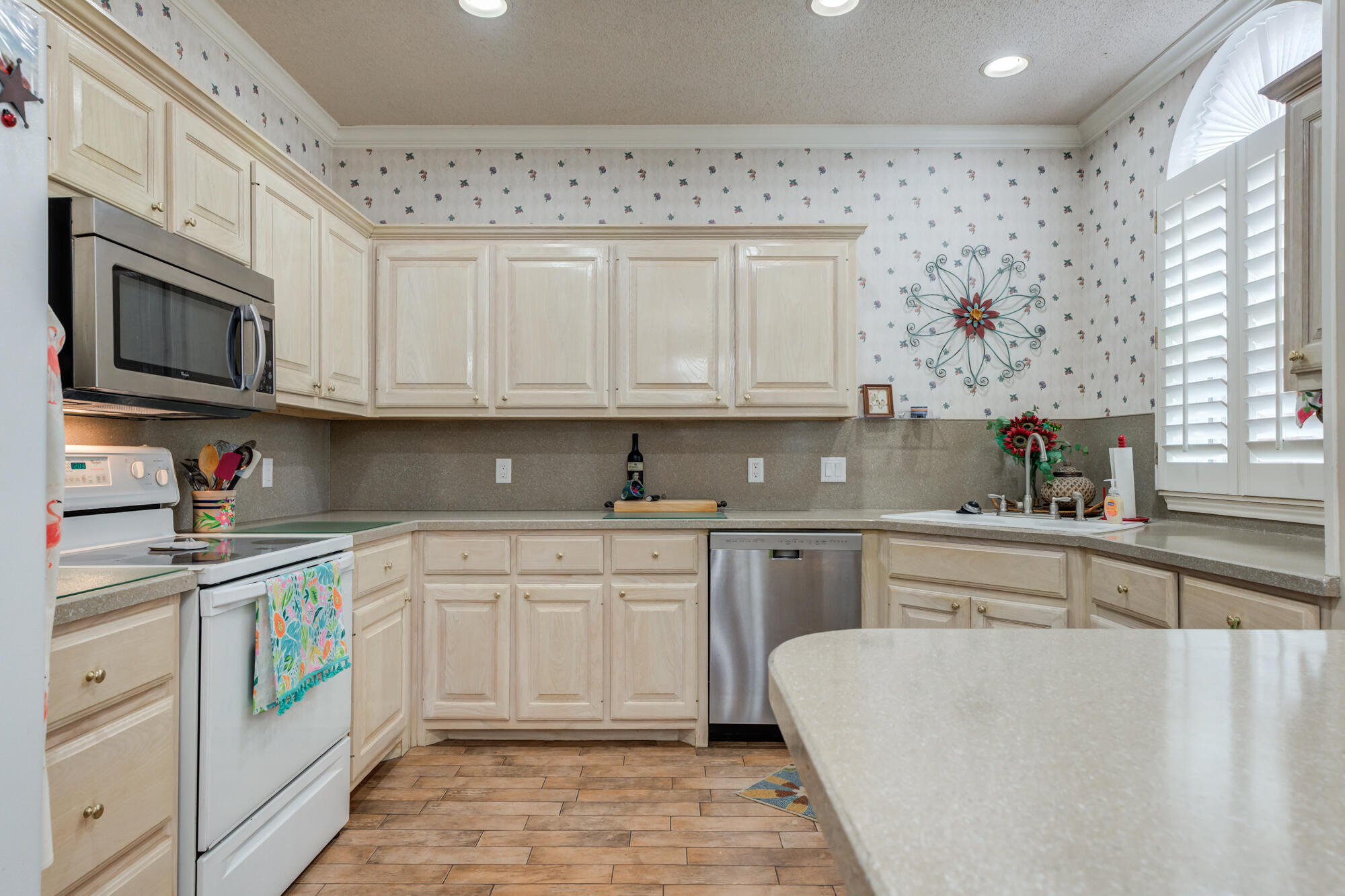 6310 8th Street Lubbock, TX 79416 - Photo 11 of 45 a kitchen with stainless steel appliances granite countertop a stove top oven a sink dishwasher and a microwave oven on the blue kitchen countertops
