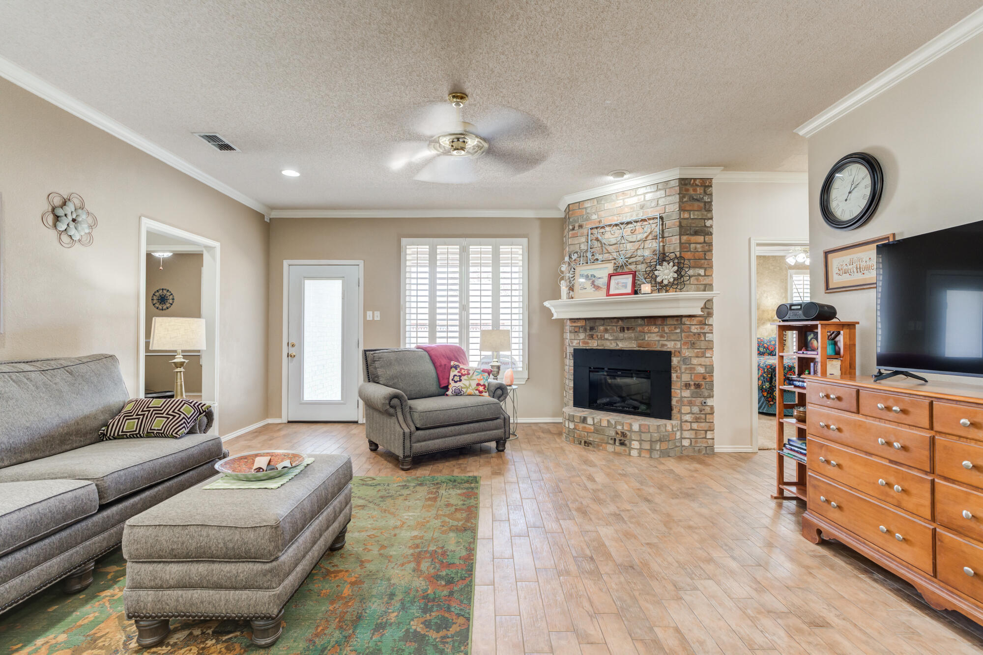 6310 8th Street Lubbock, TX 79416 - Photo 20 of 45 a living room with furniture a flat screen tv and a fireplace