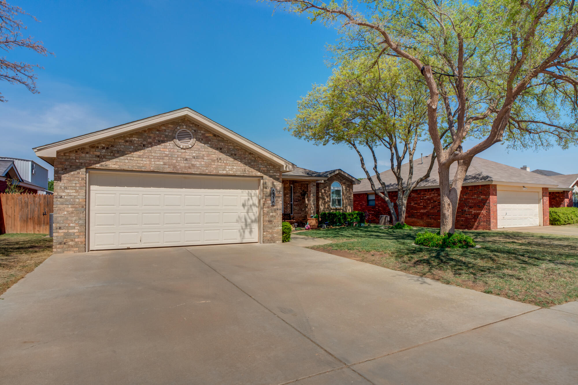 6310 8th Street Lubbock, TX 79416 - Photo 3 of 45 a front view of a house with a yard and garage