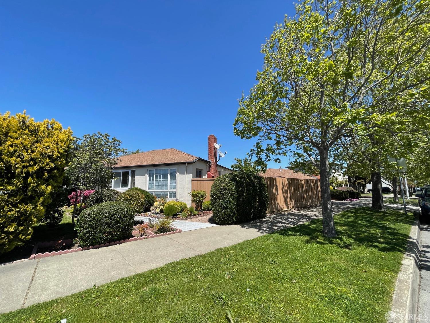 168 Park Boulevard Millbrae, CA 94030 - Photo 5 of 19 a front view of a house with a garden and trees