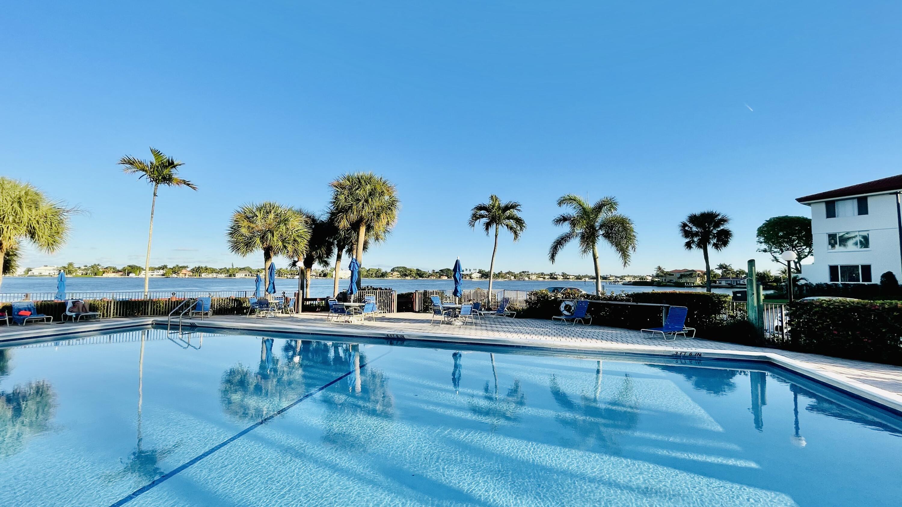 104 Half Moon Circle, Unit B2 Hypoluxo, FL 33462 - Photo 22 of 54 a view of a swimming pool and lounge chair