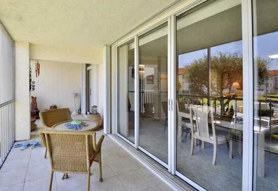 104 Half Moon Circle, Unit B2 Hypoluxo, FL 33462 - Photo 29 of 54 a dining room with furniture and a glass door
