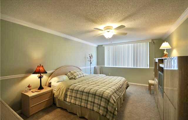 104 Half Moon Circle, Unit B2 Hypoluxo, FL 33462 - Photo 39 of 54 a bedroom with a bed and a chandelier