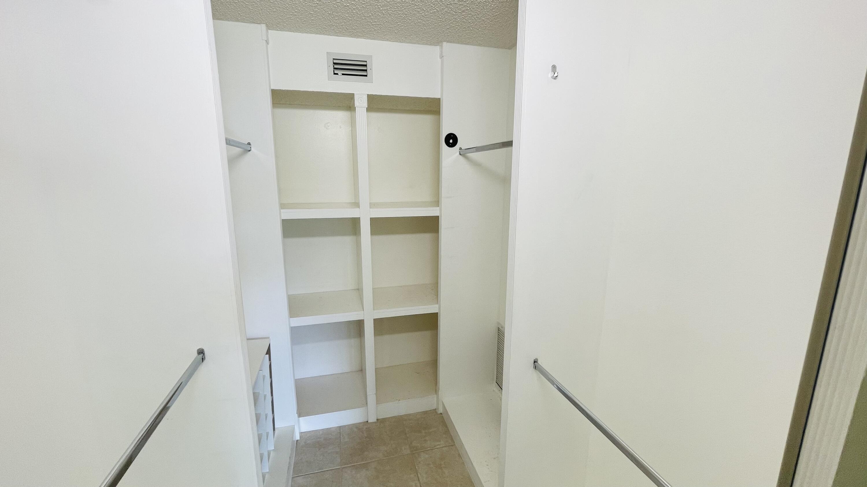 104 Half Moon Circle, Unit B2 Hypoluxo, FL 33462 - Photo 52 of 54 a view of walk in closet with empty racks