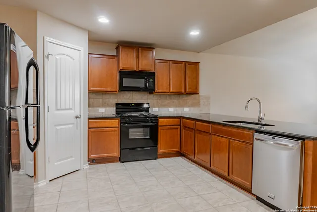 a kitchen with stainless steel appliances granite countertop a refrigerator sink and stove