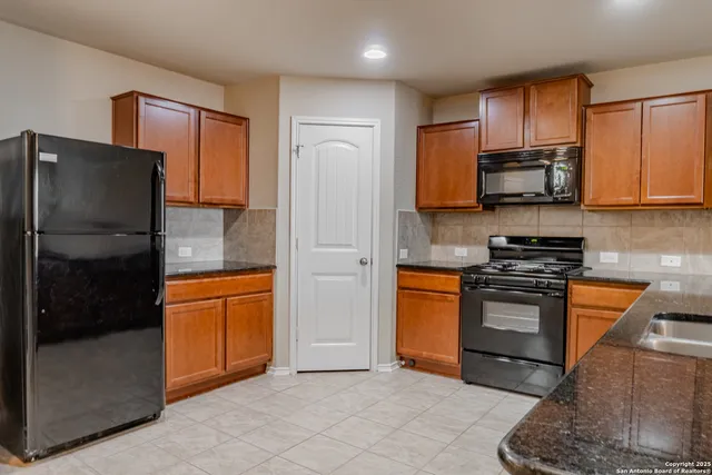 a kitchen with stainless steel appliances granite countertop a refrigerator stove and sink