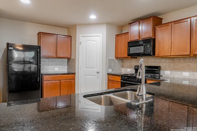 a kitchen with stainless steel appliances granite countertop a sink stove and refrigerator