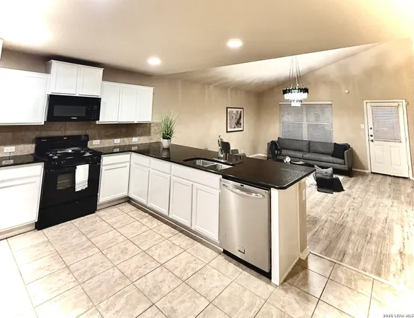 a kitchen with stainless steel appliances a sink a stove a refrigerator and cabinets