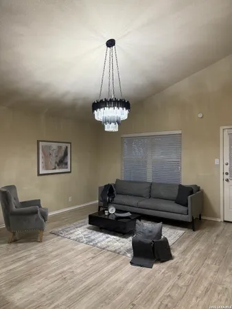 a living room with furniture and a chandelier