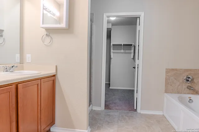 a bathroom with a tub sink and mirror
